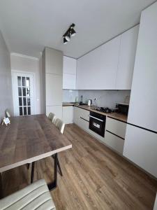 基希讷乌Транзит Сервис 4 Аэропорт- Кишинёв的配有木桌和白色橱柜的厨房