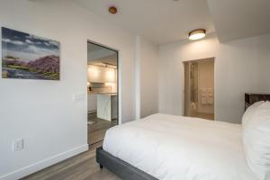 ein Schlafzimmer mit einem weißen Bett und einem Spiegel in der Unterkunft Cozy 2BR Apt with Gym and Cinema near Pier 21 in Halifax