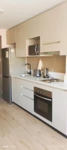 a kitchen with white cabinets and a stove top oven at Central space in Concepción