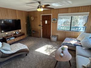 a living room with a couch and a flat screen tv at Peaceful Big Bear Cabin in Baldwin Lake