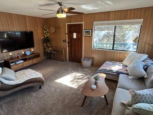a living room with a couch and a tv at Peaceful Big Bear Cabin in Baldwin Lake