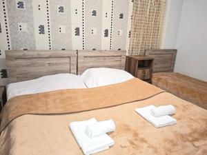 Una cama con dos toallas blancas encima. en Guest house, en Akhaltsikhe