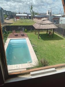 a view of a swimming pool from a window at La casita de las flores in Roldán