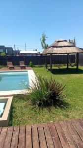 a backyard with a swimming pool and a gazebo at La casita de las flores in Roldán