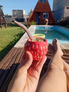 a person holding a red cup with a spoon in it at La casita de las flores in Roldán