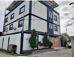 a blue and white building with trees in front of it at A Hidden Gem 2BR apartment in Couva