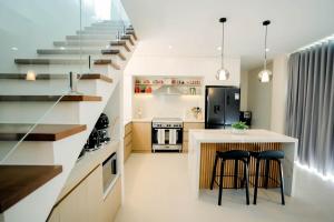 a kitchen with a staircase and two bar stools at Villa 360 in Calaca