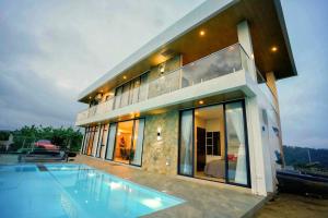 a large house with a swimming pool in front of it at Villa 360 in Calaca