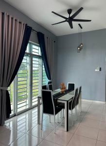 a dining room with a table and chairs and a ceiling fan at Habibie Homestay-Gunung Jerai in Guar Chempedak