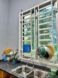 a kitchen with a sink and a window at Habibie Homestay-Gunung Jerai in Guar Chempedak