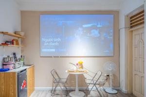 a room with a table and a projection screen on the wall at Aimee House Vũ Miên in Hanoi +25 photos