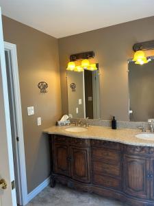een badkamer met twee wastafels en een grote spiegel bij Rutledge Lake Retreat in Bancroft +37 foto's