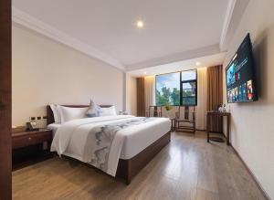 a bedroom with a large bed and a flat screen tv at Zhangjiajie Tianchong Yunhai Resort Hotel in Zhangjiajie
