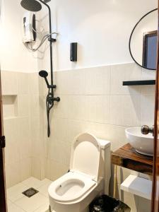 une salle de bains avec toilettes et lavabo dans l'établissement Zande Point Apartments, à General Luna 4 autres photos