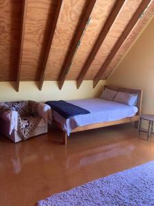 une chambre avec un lit et un plafond en bois dans l'établissement Hosts on the Coast Titoki Palms, à Matarangi