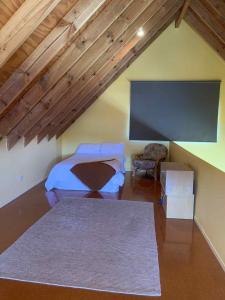 une chambre avec un lit, une télévision et une chaise dans l'établissement Hosts on the Coast Titoki Palms, à Matarangi