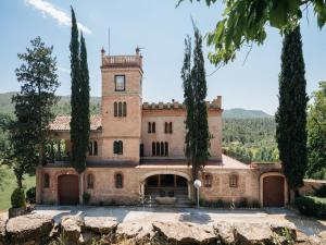 ein altes Schloss mit Bäumen davor in der Unterkunft Cottage in Castellnou with Forest Trails in Castellnou de Bages