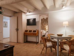 ein Wohnzimmer mit einem Tisch und ein Zimmer mit einem Bett in der Unterkunft Cottage in Castellnou with Forest Trails in Castellnou de Bages