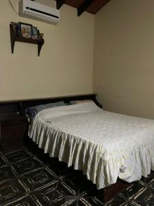 Un dormitorio con una cama con una colcha blanca. en Alojamiento a pasos de Asunción, en Fernando de la Mora 4 fotos más