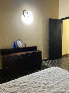 a bedroom with a dresser and a clock on the wall at Alojamiento a pasos de Asunción in Fernando de la Mora +3 photos