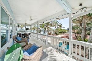 a porch with wicker chairs and a table at 111 S Atlantic Ave in Cocoa Beach
