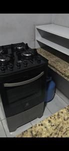 a black stove top oven sitting in a kitchen at Quarto com otima localização in Manaus +10 photos