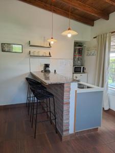 eine Küche mit einer Theke und Hockern in einem Zimmer in der Unterkunft Septimo Sol in Capilla del Monte