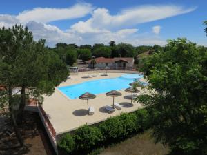 an overhead view of a swimming pool with umbrellas at Camping Le Both d'Orouet in Saint-Jean-de-Monts