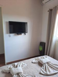 ein Schlafzimmer mit einem Bett mit einem Flachbildfernseher an der Wand in der Unterkunft Septimo Sol in Capilla del Monte + 21 Fotos