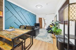 ein Wohnzimmer mit einem Tisch und einer blauen Wand in der Unterkunft The Phoenix in Swansea