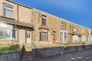 ein Backsteingebäude mit roten Türen an einer Straße in der Unterkunft The Phoenix in Swansea