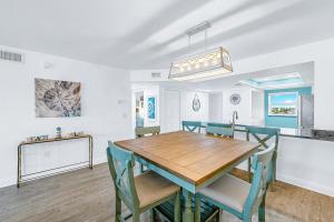 a dining room and kitchen with a wooden table and chairs at Boardwalk 205 in Cocoa Beach