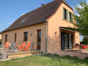 ein Haus mit orangefarbenen Stühlen auf einer Terrasse in der Unterkunft Gîte spacieux à Plazac avec jardin et animaux admis - FR-1-616-449 in Plazac
