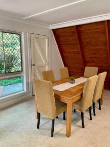 a dining room with a wooden table and chairs at Family & Friends Cottage in Mount Tamborine +33 photos