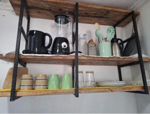 una estantería de madera con tazas y utensilios. en Seaside studio Kilifi, en Kilifi 12 fotos más