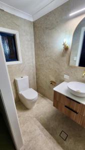 a bathroom with a toilet and a sink at Family & Friends Cottage in Mount Tamborine