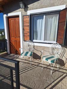 zwei Stühle und ein Tisch auf einer Terrasse in der Unterkunft Loft en las Sierras in Villa Giardino