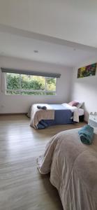 a bedroom with two beds and a large window at Casa Villa Container in Tibasosa