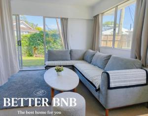 ein Wohnzimmer mit Sofa und Tisch in der Unterkunft Comfortable Stay for six and Perfect for Families in Lower Hutt