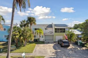 una casa con un coche aparcado en la entrada en 10 Colonial Drive, en Cocoa Beach