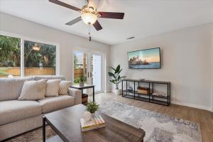 Una sala de estar con un sofá y un ventilador de techo. en 10 Colonial Drive, en Cocoa Beach