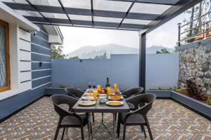 a table and chairs on a patio with a view at Riverstone Haven in Kotagiri