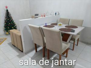 a dining room with a christmas tree and a table and chairs at Lar Doce Lar in Garanhuns