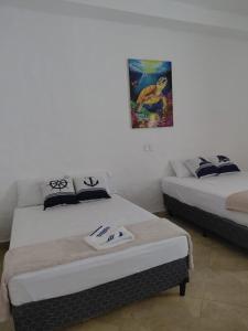 a room with two beds and a painting on the wall at El Remanso Hotel y Restaurante in Rivas