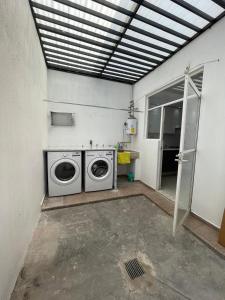 - une buanderie avec un lave-linge et un sèche-linge dans l'établissement casa santacruz, à Guadalajara
