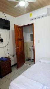 ein Schlafzimmer mit einem Bett und ein Badezimmer mit einer Toilette in der Unterkunft Melody 78 Hostel & Suites in Estelí