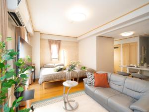 ein Wohnzimmer mit einer Couch und einem Bett in der Unterkunft The Global West in Niihama