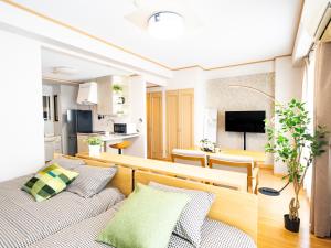 ein Wohnzimmer mit Couch und ein Esszimmer in der Unterkunft The Global West in Niihama