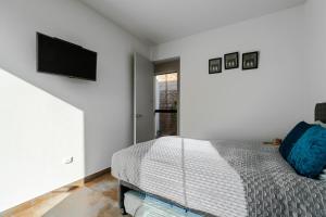 a bedroom with a bed and a tv on the wall at Casa Viña Sol - Vive la ruta del Vino y del Pisco in Ica