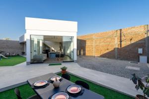 a patio with a table and chairs in a backyard at Casa Viña Sol - Vive la ruta del Vino y del Pisco in Ica